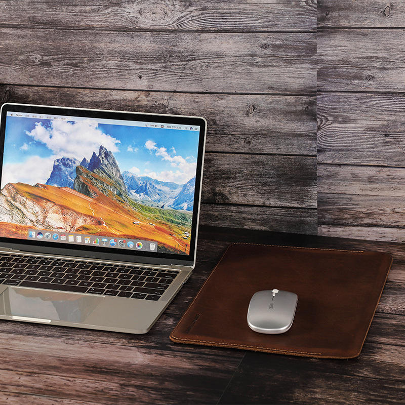 Theo als Mauspad neben MacBook auf Holzschreibtisch